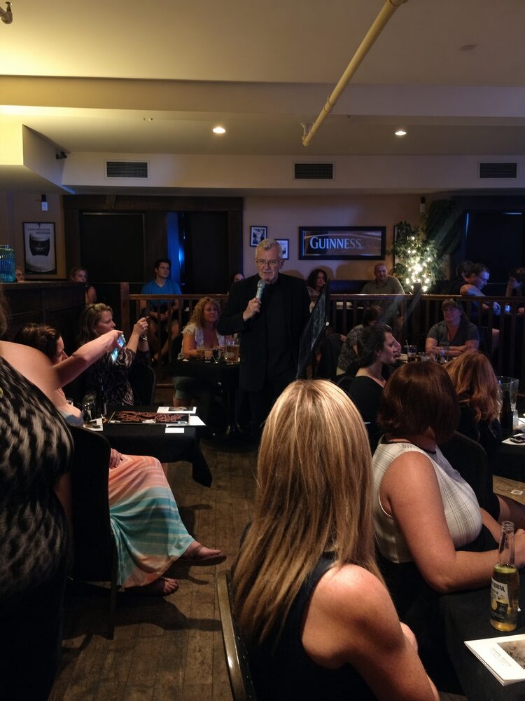 James Biss performing The Ghost Experience, addressing a seated audience at close quarters